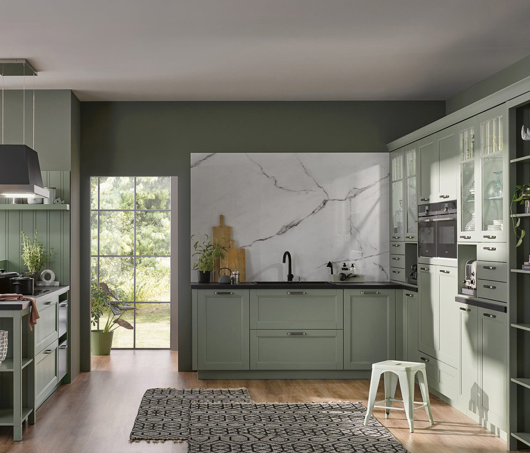 Sage green shaker cabinetry and stone backsplash